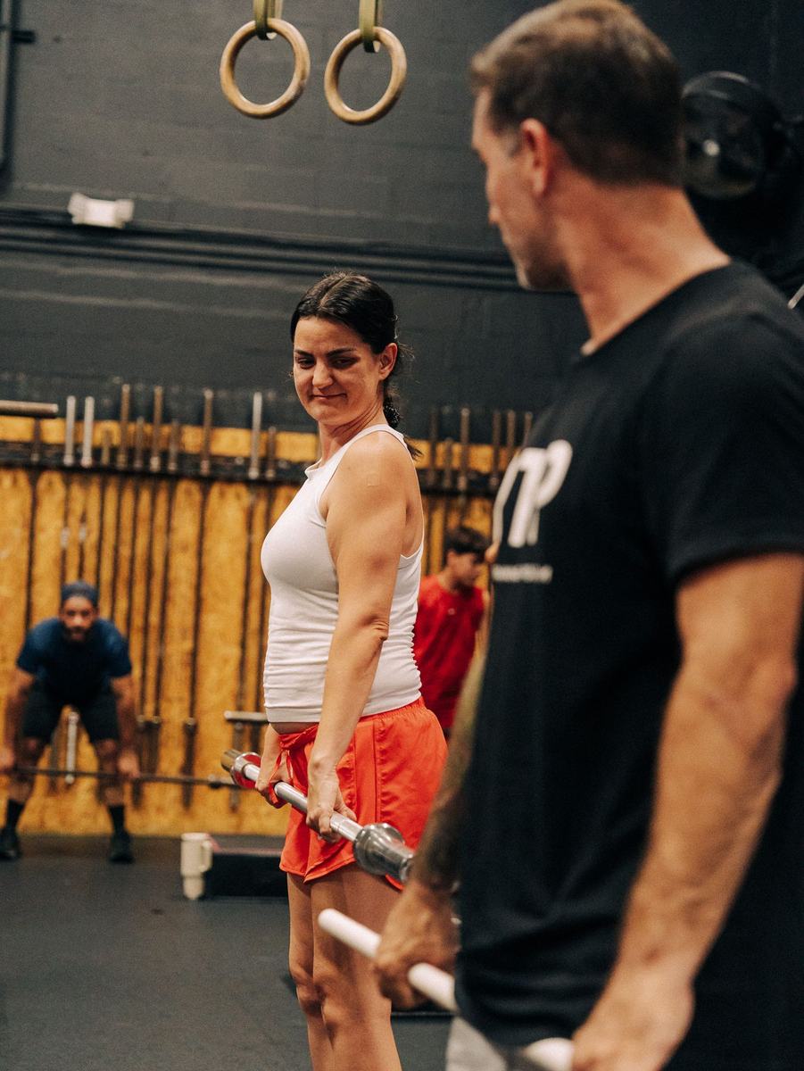 Coach cueing an athlete during a lift at RIPPED